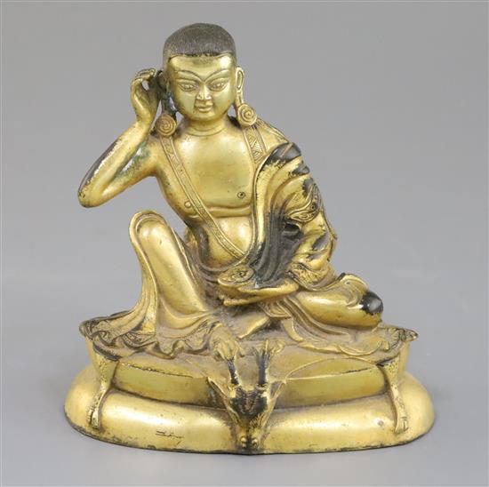 A Sino-Tibetan gilt bronze seated figure of Milarepa, H. 14cm
